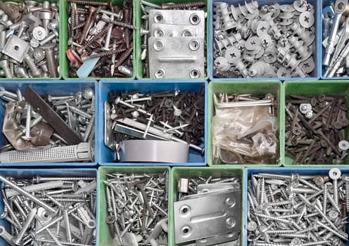 Toolbox full of metallic screws and consumable hardware