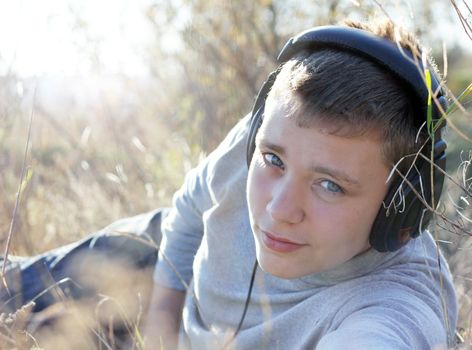 Boy Enjoying Music in autumn day in headphones