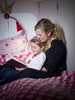 Mother and Daughter storytelling sitting on the bed