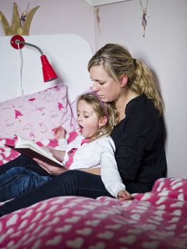 Mother and Daughter storytelling sitting in the bed