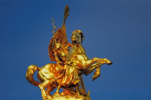 Golden statue by skulptor Emmanuel Frémiet on the top of the column of the bridge Alexander III