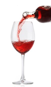 Pouring red wine into a glass isolated on white