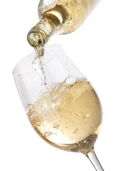 Pouring white wine into a glass, isolated on white background