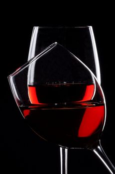 Two glasses of red wine over black background