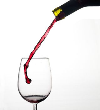 Wine splash on a glass, white background.