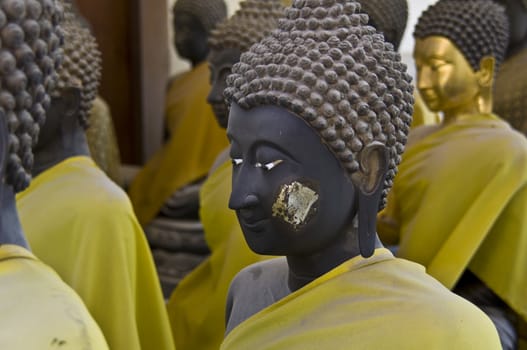 lots of statues of buddha sitting in lines