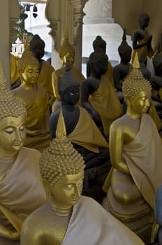 lots of statues of buddha sitting in lines