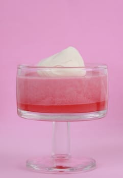 pink jelly and mousse dessert decorated with whipped cream