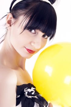 Portrait of a young beautiful brunette posing with yellow ball