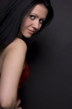 Portrait of a young beautiful brunette over black