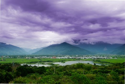 It is a beautiful mountain and clouds with tree.