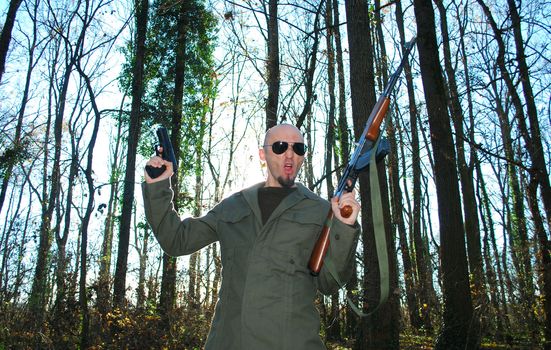 young man impersonating revolutionary in the forest with guns 