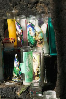 Catholic devotional candles on an outdoor stone altar