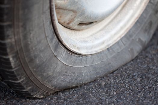 A closeup shot of a flat tire of a car