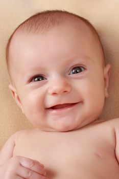 happy caucasian baby girl smiling, beige background