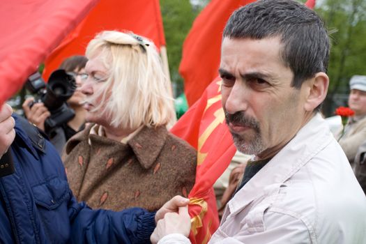 RIGA, LATVIA, MAY 9, 2009: Vladimir Linderman, member of the banned National Bolshevik party (NBP) is arrested for using forbidden Soviet Union flag. Celebration of May 9 Victory Day (Eastern Europe) in Riga at Victory Memorial to Soviet Army