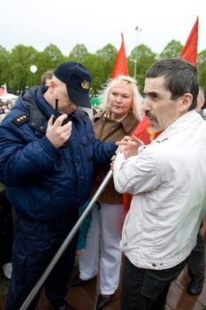RIGA, LATVIA, MAY 9, 2009: Vladimir Linderman, member of the banned National Bolshevik party (NBP) is arrested for using forbidden Soviet Union flag. Celebration of May 9 Victory Day (Eastern Europe) in Riga at Victory Memorial to Soviet Army