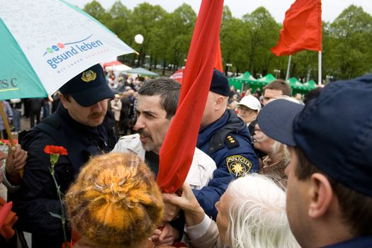 RIGA, LATVIA, MAY 9, 2009: Vladimir Linderman, member of the banned National Bolshevik party (NBP) is arrested for using forbidden Soviet Union flag. Celebration of May 9 Victory Day (Eastern Europe) in Riga at Victory Memorial to Soviet Army