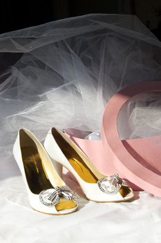 Wedding shoes, box and veil over dark background