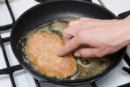 Chicken cutlets roasting on frying-pan