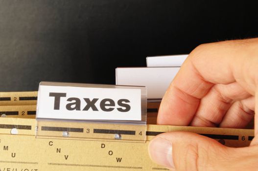 tax or taxes concept with word on business folder index