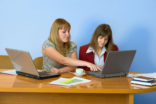 Young girls work sitting at a table