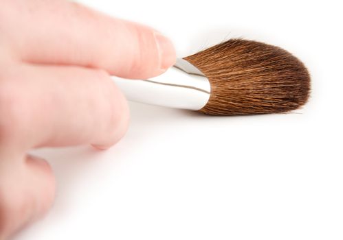 Hand holding a cosmetics brush