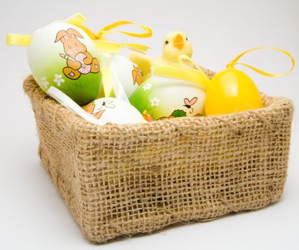 Easter eggs and chick in a cloth basket