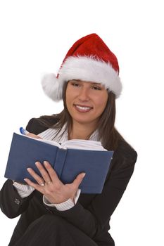 Young woman with Santa's hat taking notes about the desired Christmas gifts. 