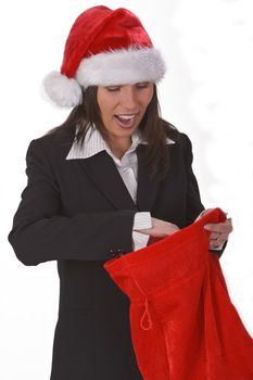 Happy young woman in a red hat discovering gifts in Santa's sack