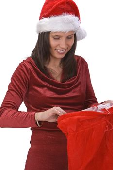 Young woman in red clothes and hat looking for the gifts in Santa's sack.Shot with Canon 70-200mm f/2.8L IS USM