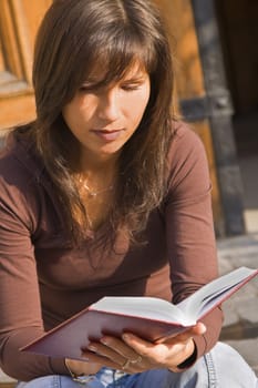 Image of a girl student reading something from a notebook.