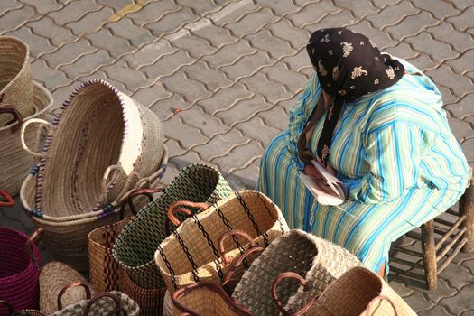 Woman selling bags in a street market in Marrakesh (Place des Epices)