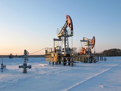 Oil pump jack in work. Oil industry in West Siberia. Siberian frost in sunny day.