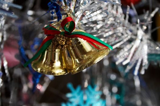 Gold handbells on a silver christmas fur-tree