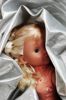 Small doll wrapped up in a silver fabric