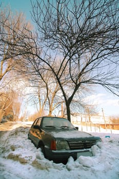 The car fallen asleep by a snow in a court yard