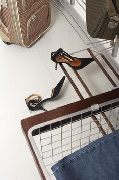Black shoes, suitcases and jeans in wardrobe