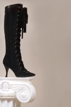 Black female boot on a white curbstone