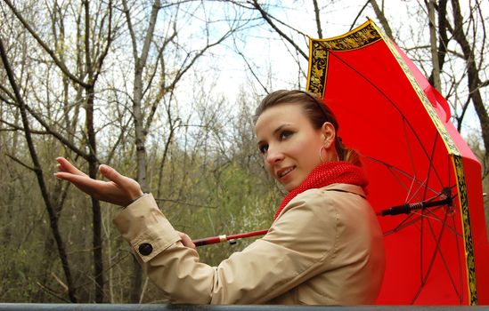 woman with red umbrella checking if it's raining
