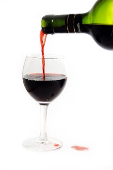Green bottle pouring red wine into wineglass ..