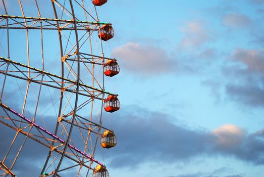 Section of ferris wheel against blue cloudy sky
