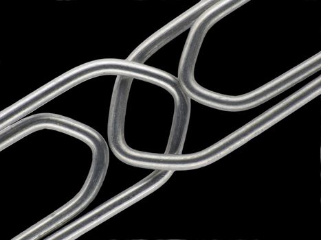 Two linked paperclips on a black background