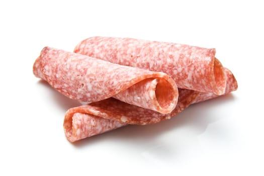 Slices of rolled salami isolated over white background
