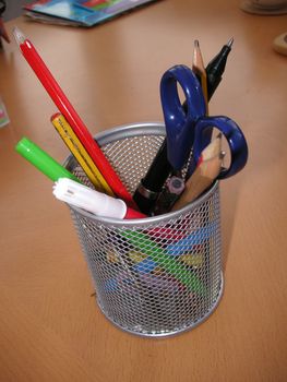 mesh container with desk accessories inside