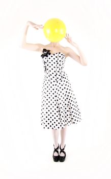 Portrait of a young beautiful brunette posing with yellow ball