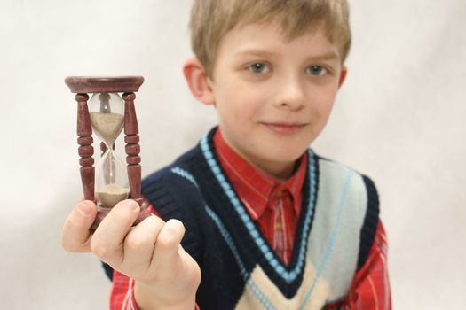 Young boy with old sandglass