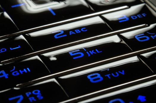 Close up shot of blue mobile keypad under dark environment
