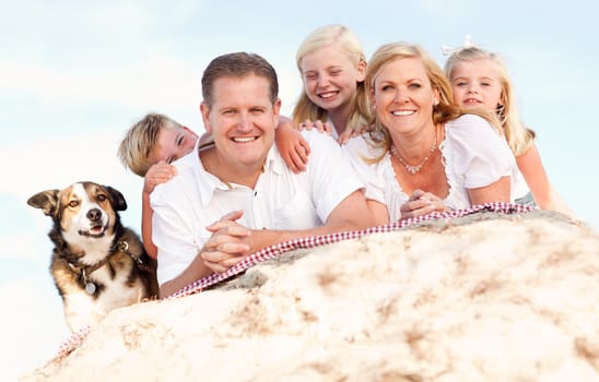 Happy Caucasian Family and Dog Portrait at the Beach One Sunny Afternoon.