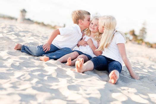 Adorable Sibling Children Kissing the Youngest Girl at the Beach.